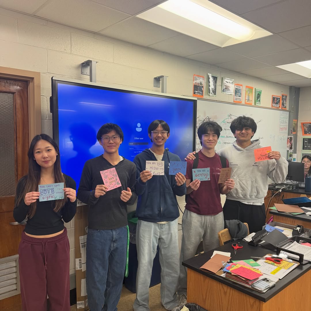 Students at a classroom cardmaking event holding handmade cards for hospitalized kids